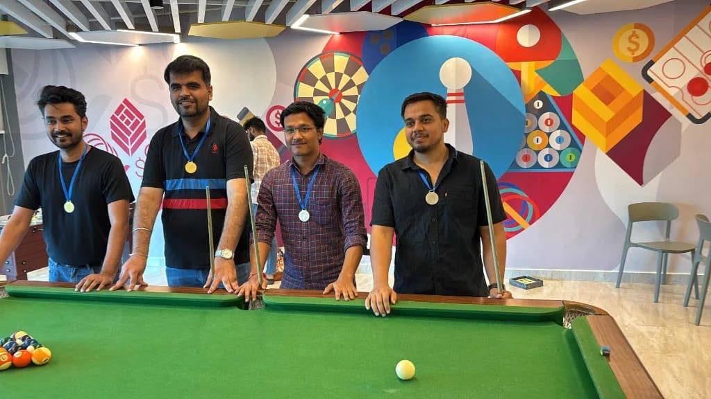 Team celebrating at the office pool table