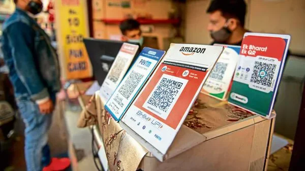 UPI QR payment placards at a shop counter — Mint coverage of cashback strategies